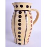 A 19TH CENTURY SLIP DECORATED POTTERY JUG painted with brown dot decoration. 24 cm high.