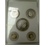 A CASED SET OF FIVE CHINESE WHITE METAL COINS, varying size. Largest 4 cm.