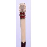 AN UNUSUAL CONTINENTAL SILVER GILT IVORY AND ENAMEL DOG HEAD WALKING CANE decorated with swirling a