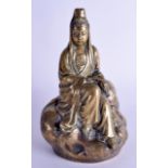 A CHINESE QING DYNASTY GILT BRONZE FIGURE OF GUANYIN modelled seated holding a scroll upon a boulde