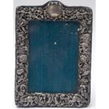 A SOLID SILVER VICTORIAN PICTURE FRAME, decorated with figures and foliage. 17.5 cm x 12.5 cm.