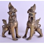 A PAIR OF 19TH CENTURY INDIAN EASTERN BRONZE BUDDHIST BEASTS modelled standing upon there front leg