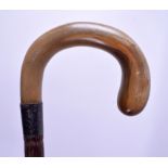 A 19TH CENTURY CARVED RHINOCEROS HORN HANDLED WALKING CANE of scrolling form. 87 cm long.