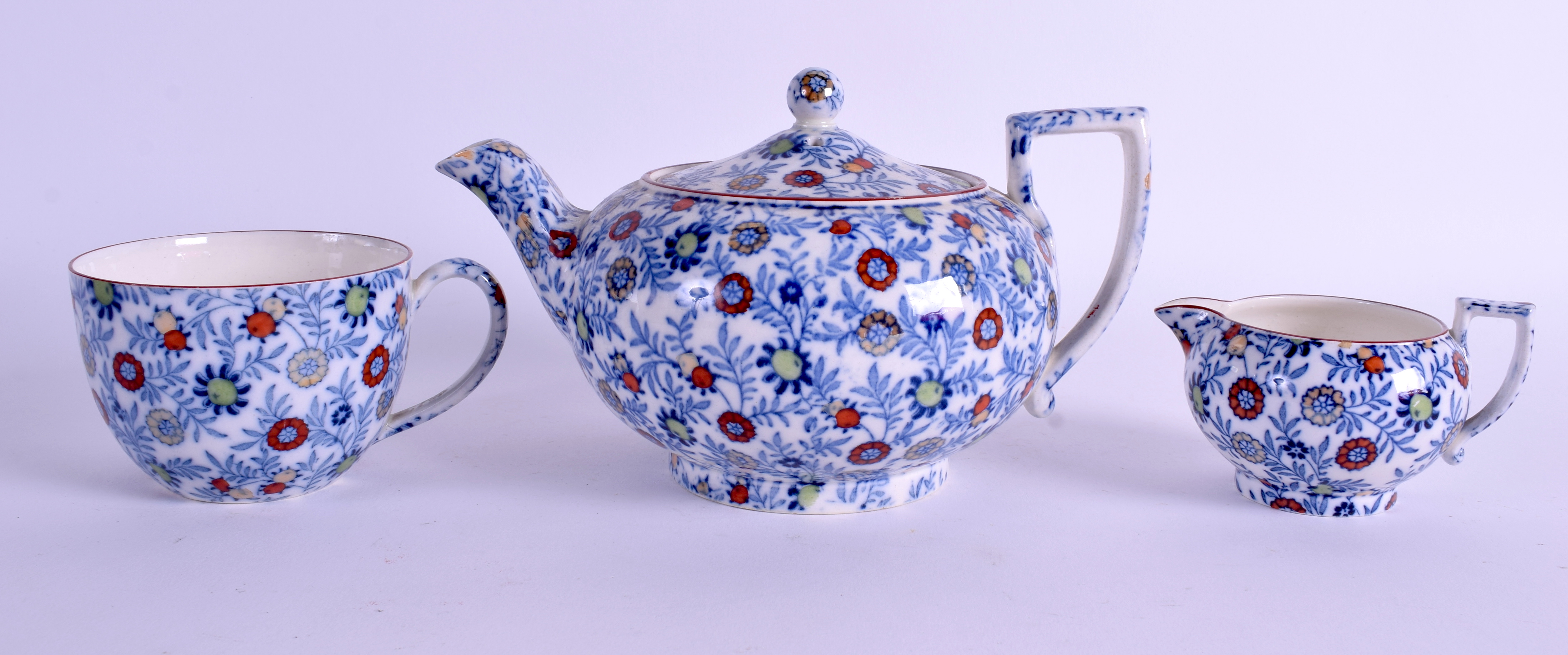 AN ANTIQUE CHINTZ TEAPOT AND COVER together with two others. Largest 19 cm wide. (3)