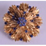 A GOOD 18CT GOLD SAPPHIRE INSET BROOCH, in the form of a flower. 3.5 cm wide & weight 15 grams.