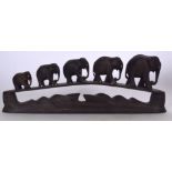 AN EARLY 20TH CENTURY AFRICAN WOODEN ELEPHANT GROUP, formed upon a carved plinth. 38.5 cm wide.