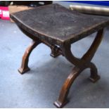 AN ANTIQUE X FRAME LEATHER UPHOLSTERED STOOL, decorated with foliage. 45 cm wide.