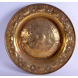 A 19TH CENTURY BRASS ALMS DISH decorated with figures and motifs. 45 cm wide.