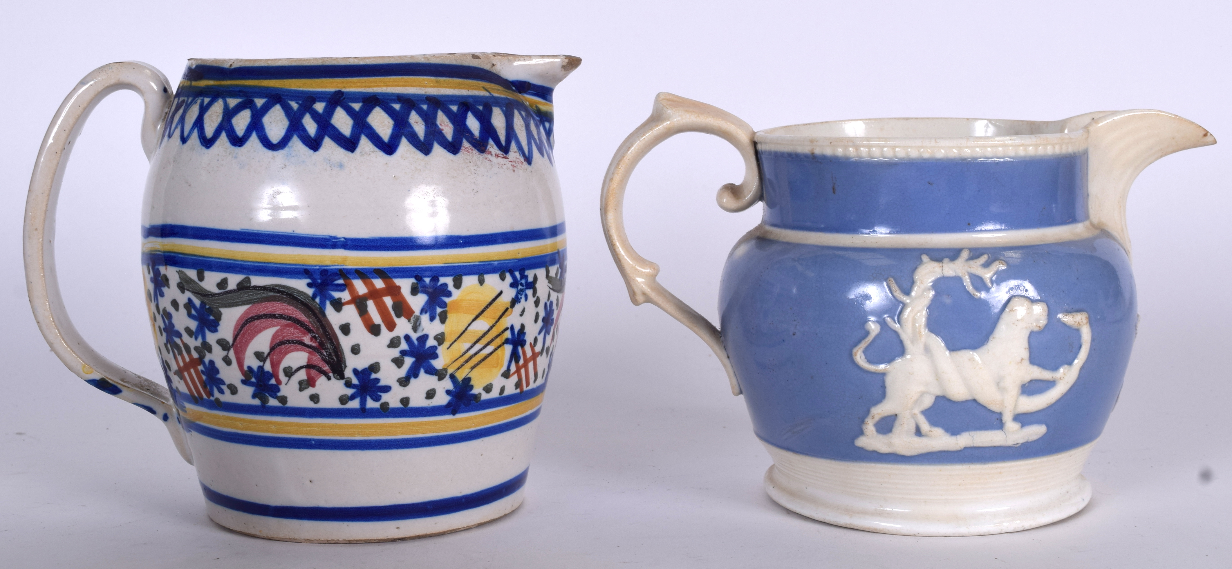 AN ANTIQUE FAEINCE POTTERY JUG, together with a mauve porcelain example decorated in relief with an