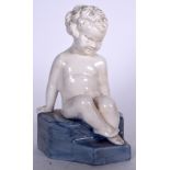 AN ASHSTEAD POTTERS LTD PORCELAIN FIGURINE OF A SEATED CHILD, formed upon a stepped plinth. 22 cm h