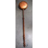 A 19TH CENTURY COPPER BED WARMING PAN, etched with a male playing a pipe. 128 cm long.