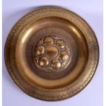 A LARGE ARTS AND CRAFTS BRASS ALMS DISH decorated with script and fruiting pods. 40 cm diameter.