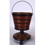 AN EARLY 20TH CENTURY WOODEN BUCKET, formed with brass liner and ribbed body. 59 cm to handle.