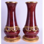 A PAIR OF LATE 19TH CENTURY SEVRES PORCELAIN VASES mounted in gilt foliage. 27 cm high.