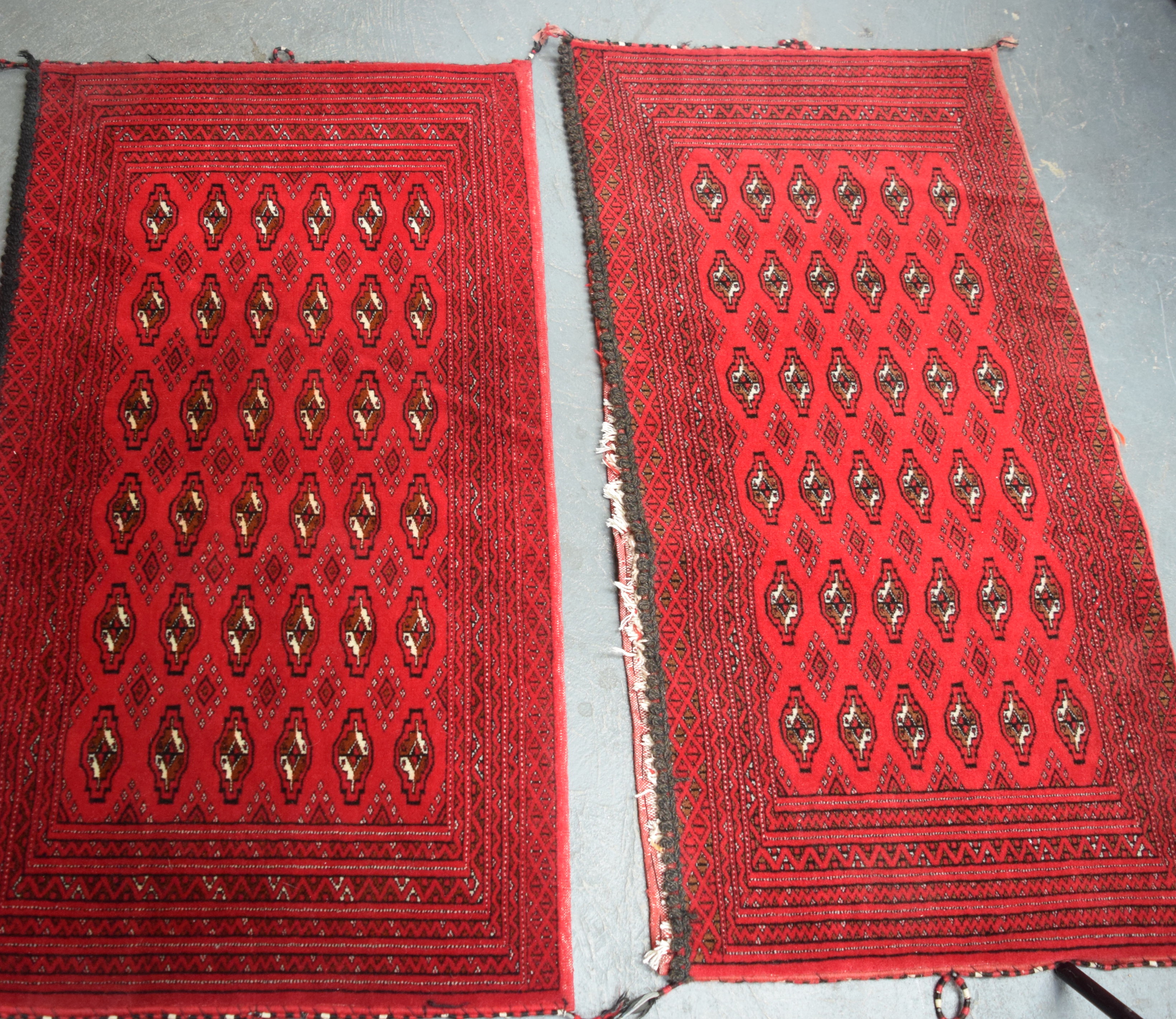 A PAIR OF MID 20TH CENTURY RED GROUND TEKKE TURKMEN SADDLE BAG, decorated with motifs. 114 cm x 63