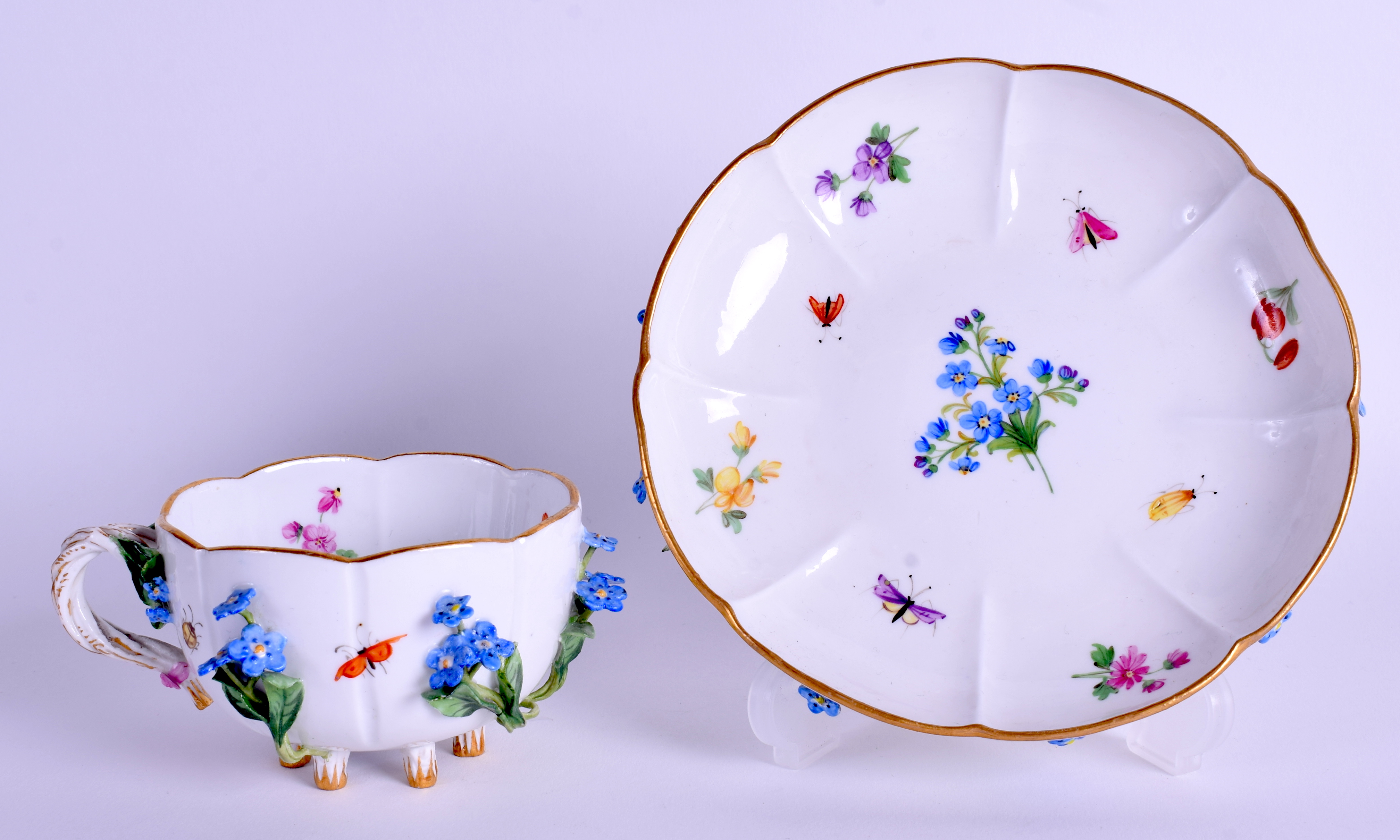 A MEISSEN ENCRUSTED PORCELAIN CUP AND SAUCER encrusted with flowers. (2)