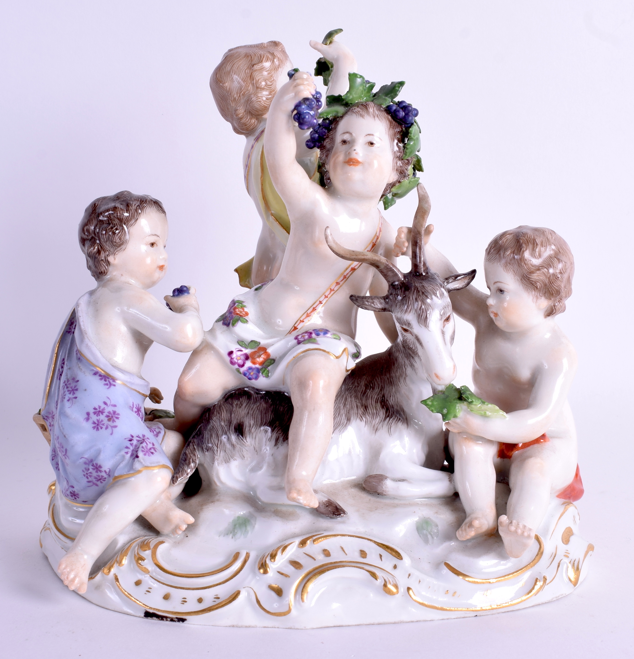 A 19TH CENTURY MEISSEN PORCELAIN FIGURE OF FOUR CHILDREN modelled seated upon a recumbent deer. 18