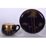 AN UNUSUAL JAPANESE BLUE GROUND SATSUMA POTTERY TEA CUP AND SAUCER, decorated with gilt foliage, si