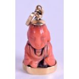 AN 18CT GOLD CHINESE CORAL PENDANT OR CHARM, in the form of a seated buddha. 2.7 cm & weight 4 gram