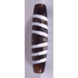 A CHINESE CARVED AGATE ZHU BEAD OR DZI BEAD, formed with swirling decoration. 6.75 cm long.