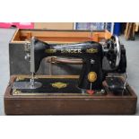 AN ANTIQUE SEWING MACHINE, with original case. 50.5 cm wide.