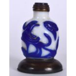 A CHINESE QING DYNASTY PEKING GLASS SNUFF BOTTLE, formed upon a bronze base. 9 cm high.