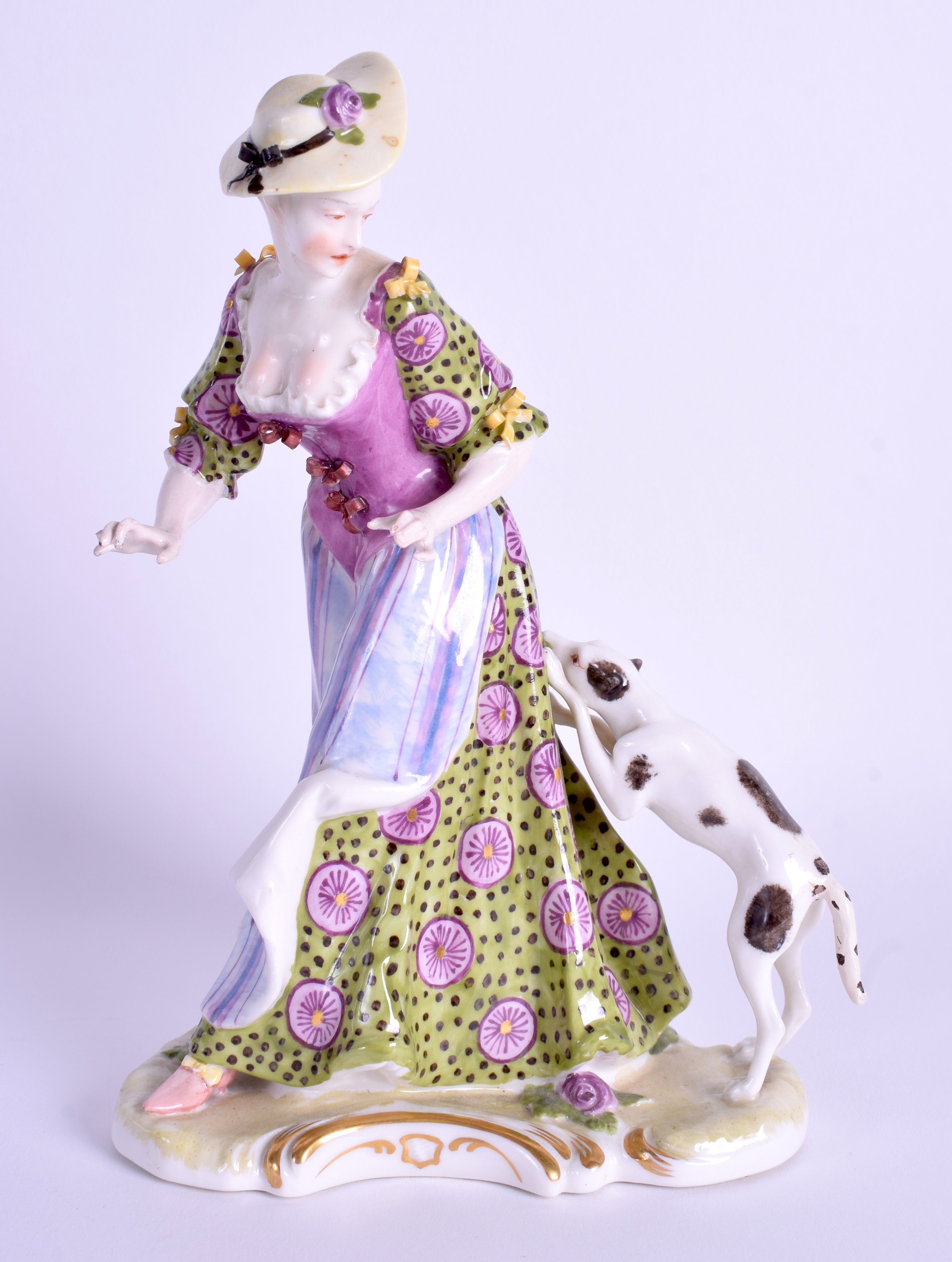 A 19TH CENTURY GERMAN PORCELAIN FIGURE OF A FEMALE modelled in a coloured dress beside a hound. 19