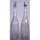 A PAIR OF EARLY 20TH CENTURY GLASS DECANTERS, etched with foliage. 37 cm high.