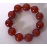 A CHINESE CARVED AGATE BRACELET, formed with spherical beads and yellow metal spacers. 9 cm wide, b