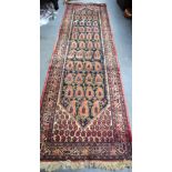 AN EARLY 20TH CENTURY PERSIAN RUNNER RUG, decorated with foliage and motifs. 330 cm x 90 cm.