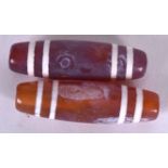 A PAIR OF CHINESE AGATE ZHU OR DZI BEADS, decorated with white banding. 4.5 cm wide.