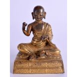 A FINE 18TH CENTURY CHINESE TIBETAN GILT BRONZE FIGURE OF LUOHAN modelled seated upon a foliate inc