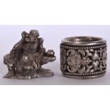 A CHINESE WHITE METAL REVOLVING RING, together with a small statue. (2)