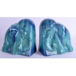 AN UNUSUAL PAIR OF 1950S CONTINENTAL BLUE GLAZED FLAMBE POTTERY BOOKENDS in the form of elephants.