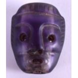 A VERY UNUSUAL CARVED PURPLE STONE MASK HEAD. 3.5 cm x 2.75 cm.