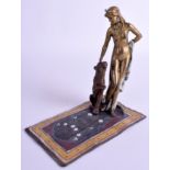 A COLD PAINTED BRONZE FIGURE OF A LADY modelled upon a rug. 18 cm x 15 cm.