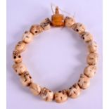 AN ASIAN CARVED BONE SKULL NECKLACE. 34 cm long.