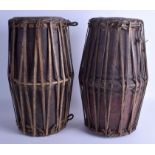 AN UNUSUAL PAIR OF EARLY 20TH CENTURY AFRICAN TRIBAL HIDE AND WOOD DRUMS engraved with motifs. 42 c