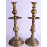 A PAIR OF ANTIQUE EUROPEAN BRASS CANDLESTICKS. 37 cm high.