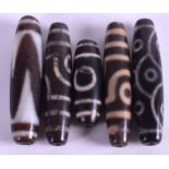 FIVE CHINESE TIBETAN CARVED AGATE ZHU BEADS. Largest 5.75 cm long. (5)