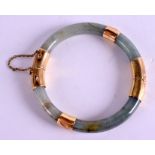 A CHINESE 14CT GOLD AND JADEITE BANGLE. 7 cm wide.