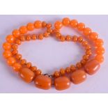 A 1920S HONEY ORANGE AMBER BUTTERSCOTCH TYPE NECKLACE. 49 grams. 60 cm long, largest bead 1.75 cm w