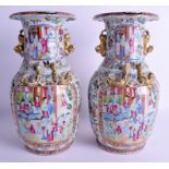 A PAIR OF 19TH CENTURY CHINESE CANTON FAMILLE ROSE VASES Qing, painted with figures within landscap