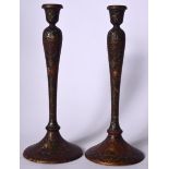 A PAIR OF LATE 19TH CENTURY PERSIAN QAJAR LACQUERED CANDLESTICKS, painted with portraits. 28 cm hig