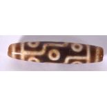 AN EARLY 20TH CENTURY CHINESE CARVED AGATE DZI OR ZHU BEAD, decorated with symbols. 5.5 cm long.