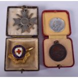 A VINTAGE LIFE SAVING MEDALLION together with two others and a 1939 military cross. (4)