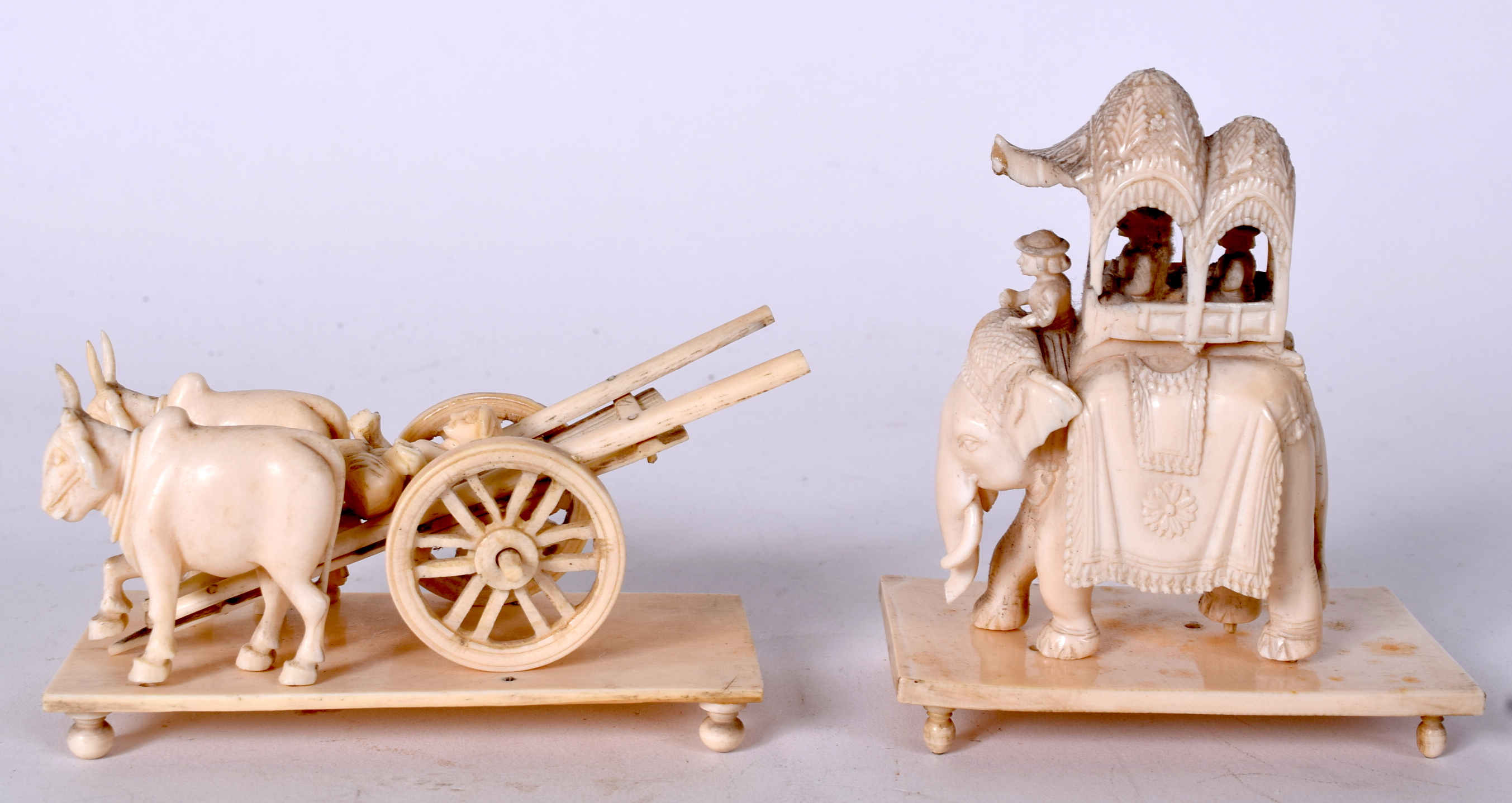 AN EARLY 20TH CENTURY INDIAN CARVED IVORY FIGURE ON AN ELEHANT, together with two oxon pulling a ca