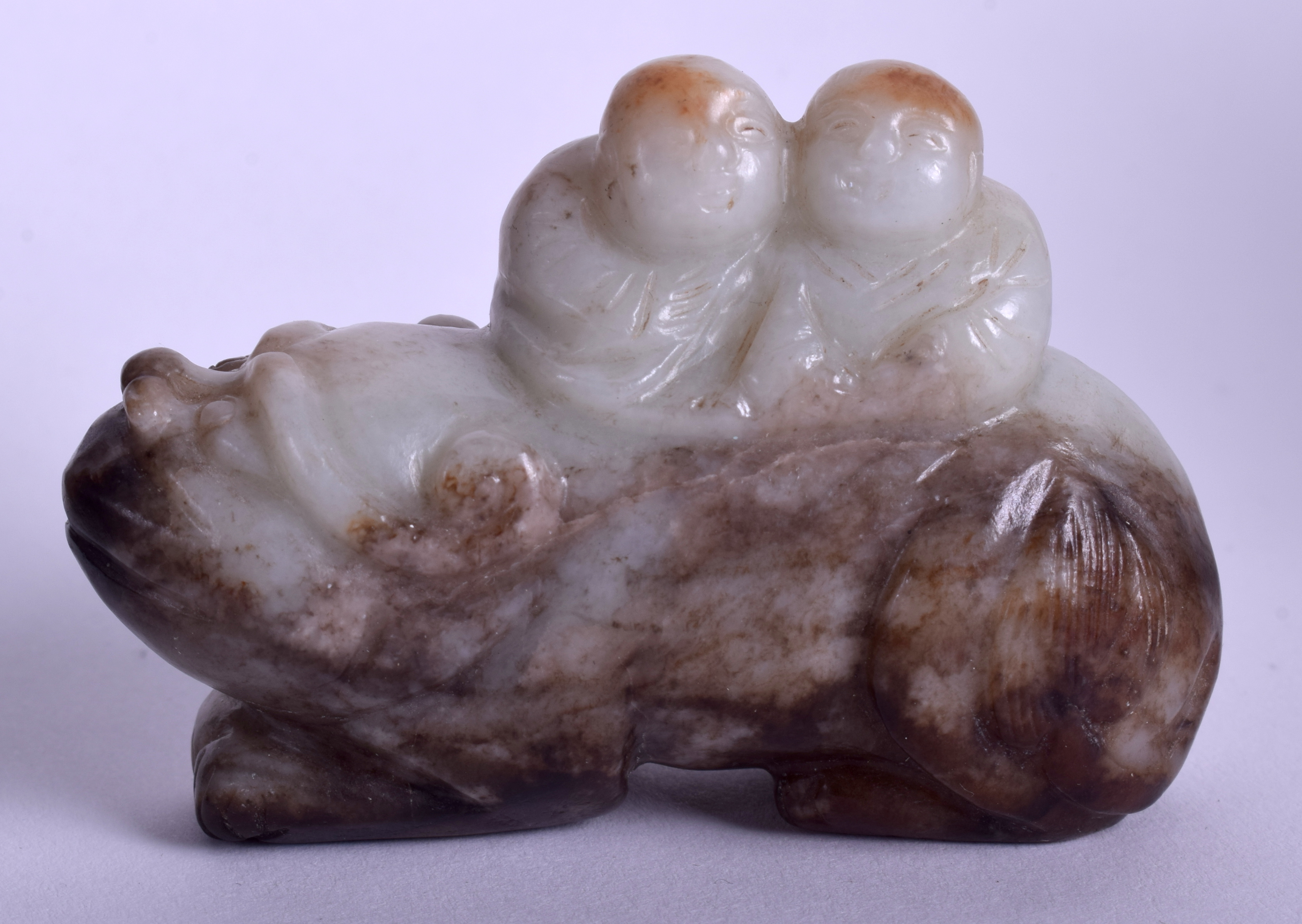 A 19TH CENTURY CHINESE CARVED MUTTON GREEN JADE BEAST modelled with two attendants on board. 6.5 cm