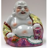 A CHINESE PORCELAIN BUDDHA FORMED AS HOTEI, modelled seated holding prayer beads. 21.5 cm x 19 cm.