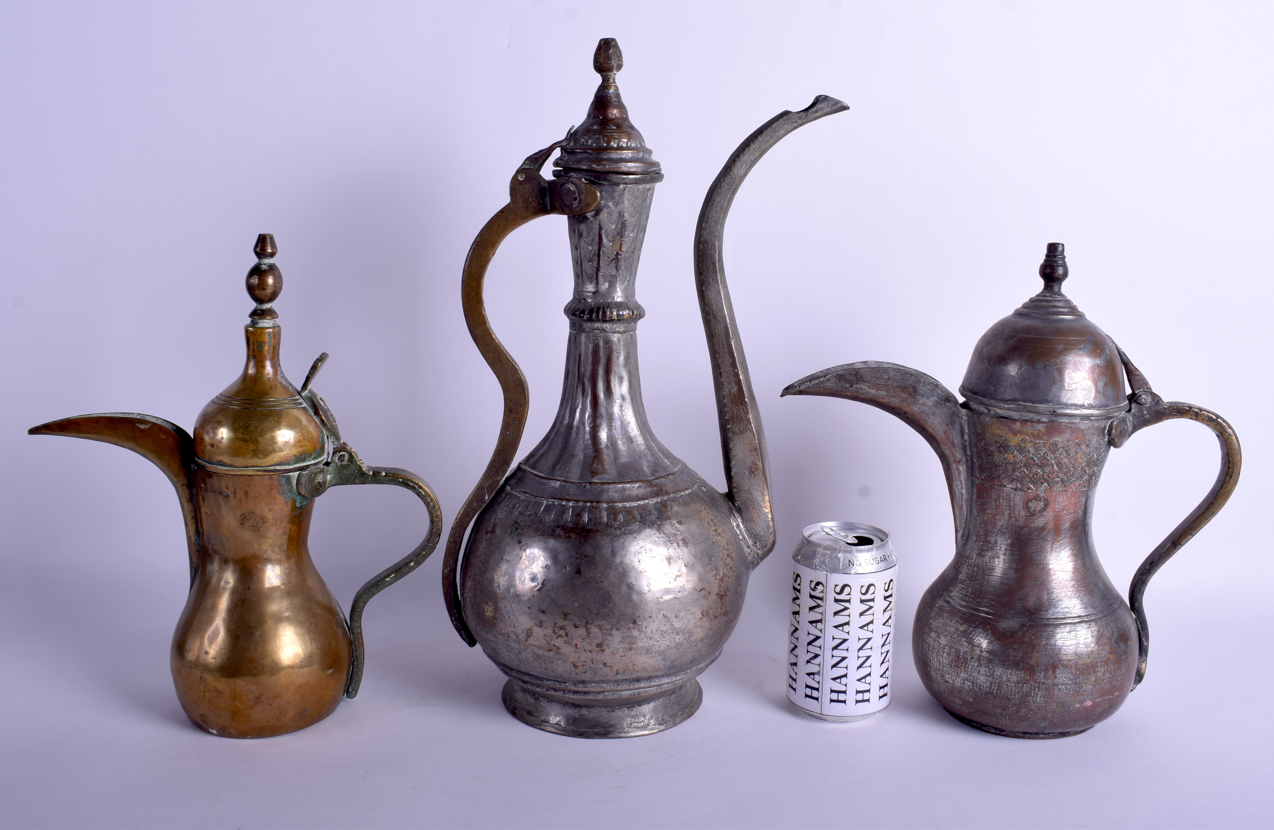 THREE ANTIQUE MIDDLE EASTERN TURKISH BRONZE STEEL EWERS in various forms. Largest 42 cm x 21 cm. (3